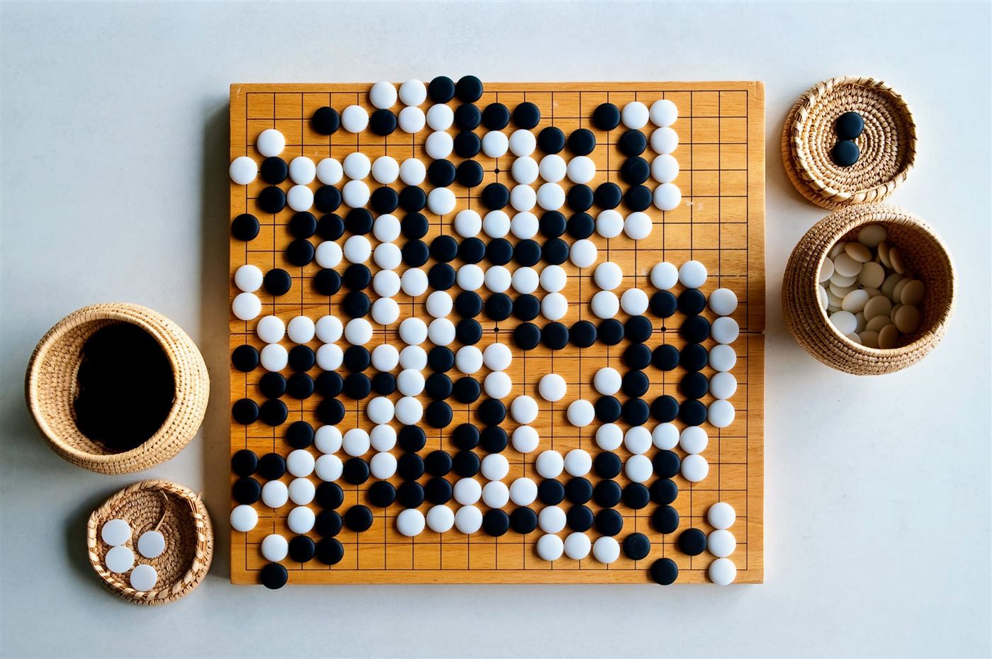 A full Go board with stone bowls