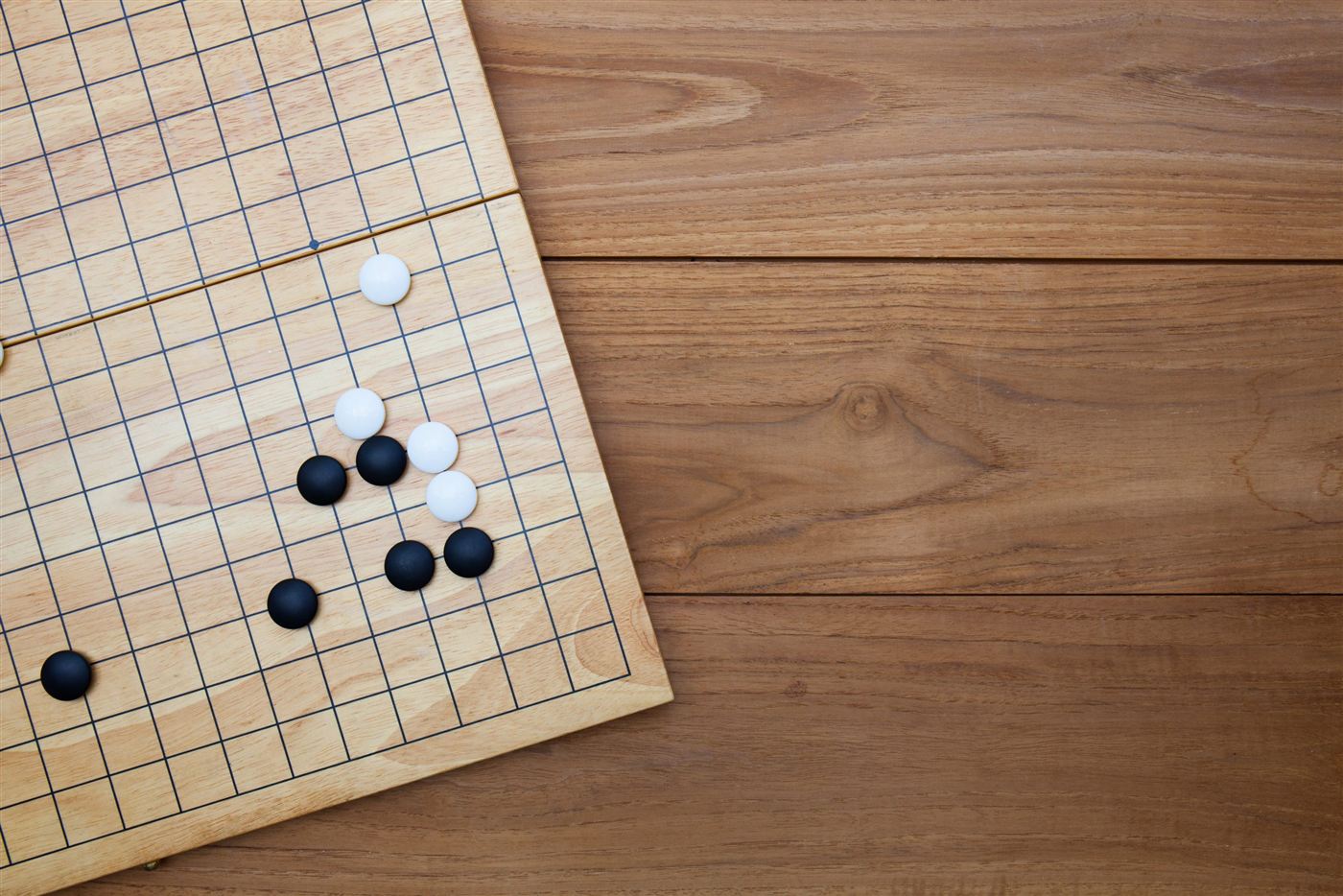 Go stones on a wooden board